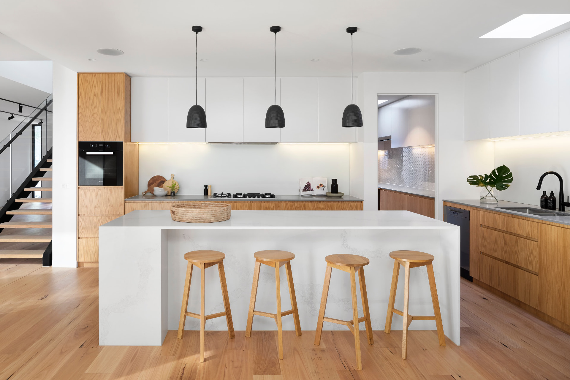 Renovated kitchen with oak cabinetry and stone waterfall island
